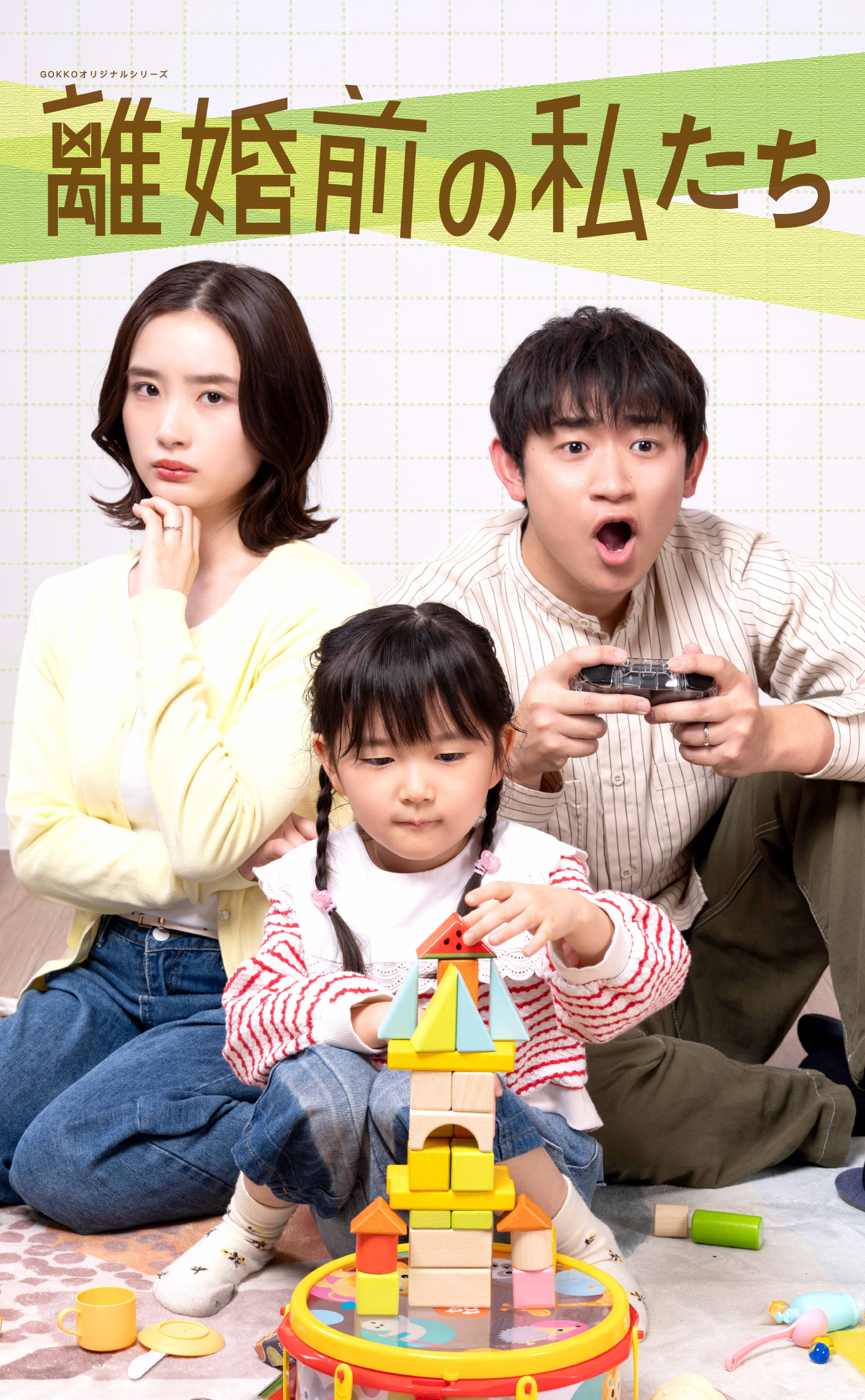 A family of three building a colorful wooden block tower together; a young girl concentrates on stacking while her parents watch.