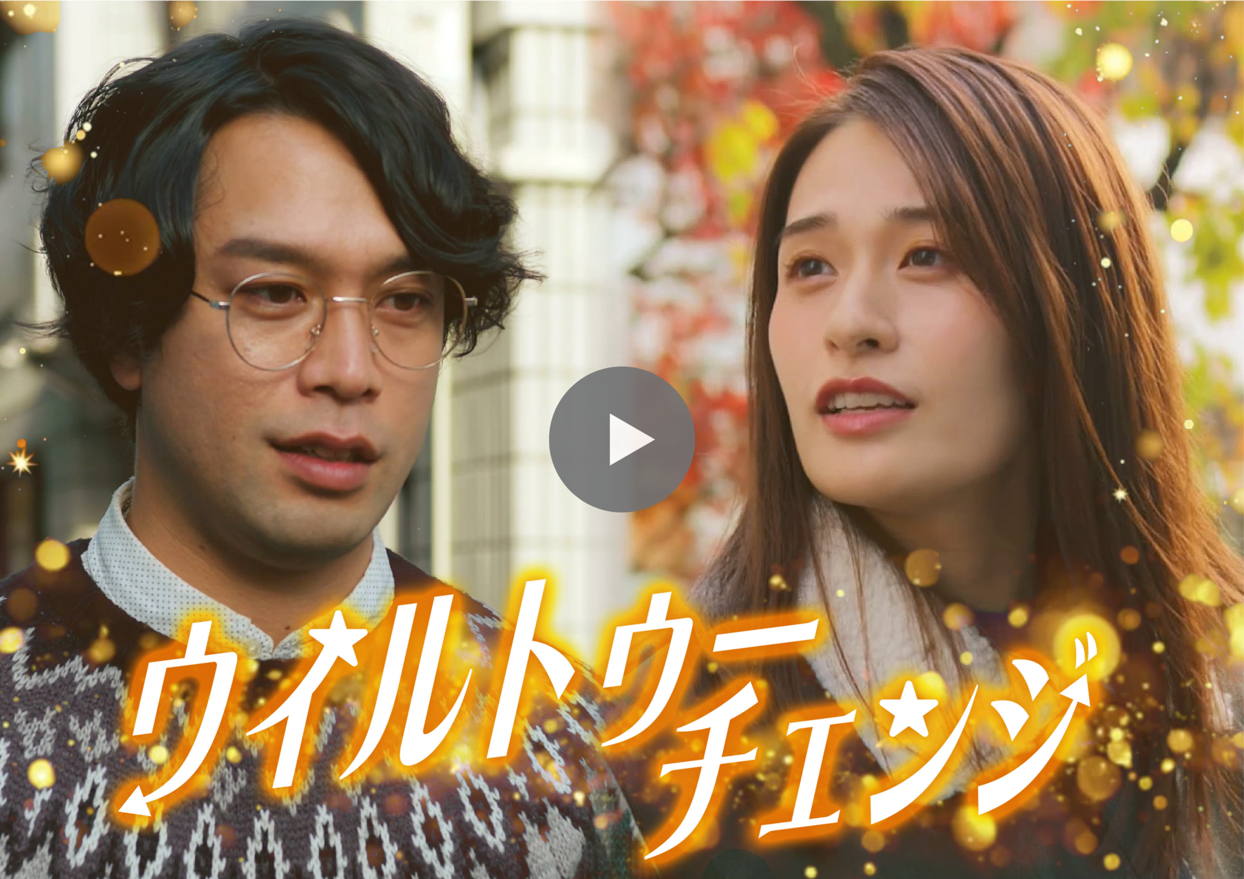 Video thumbnail showing a man with glasses and a woman outdoors, with a play button overlay and festive golden confetti effects in the background.