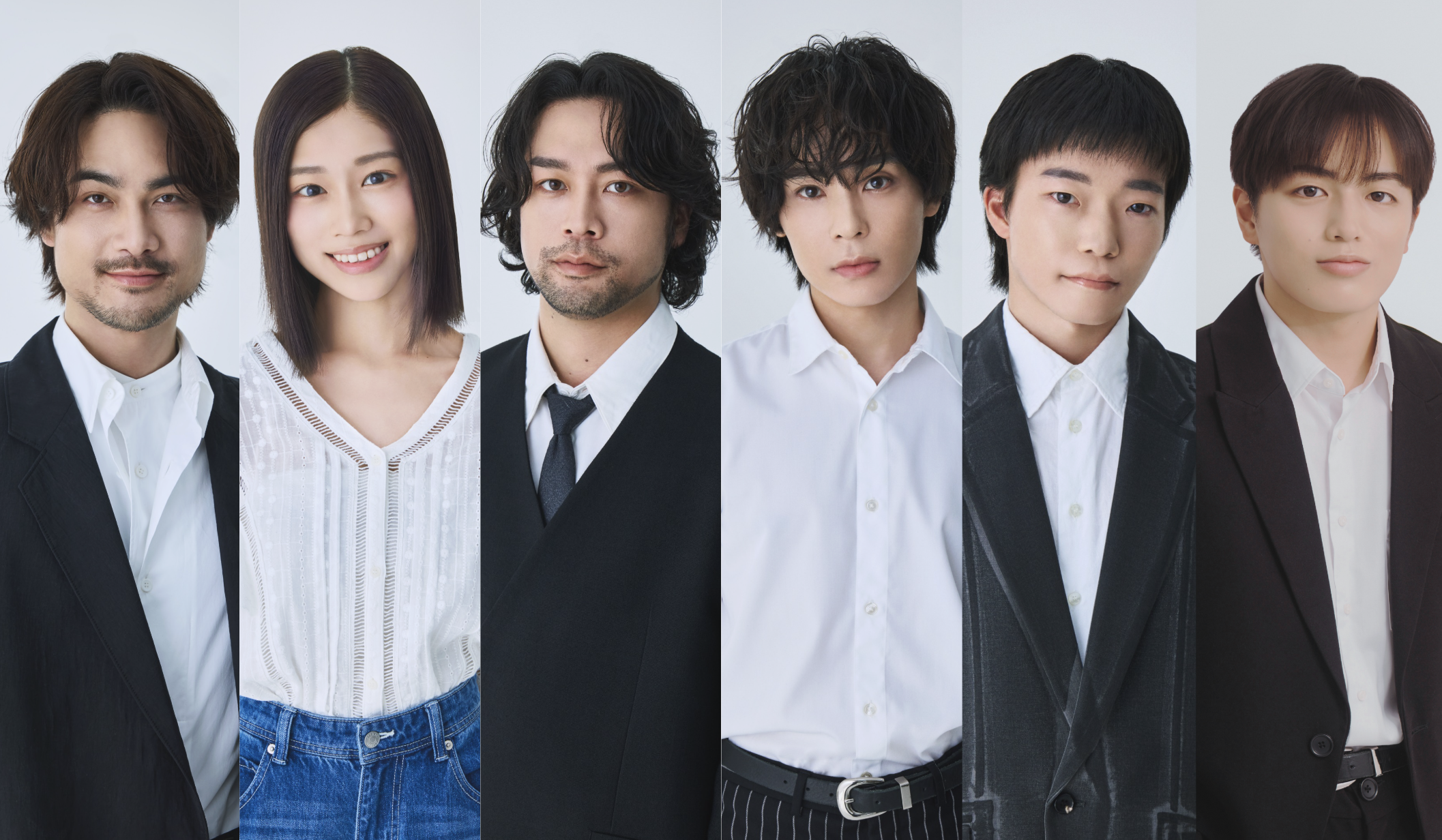 Group portrait of seven young professionals in business attire posing in a studio, each looking at the camera.