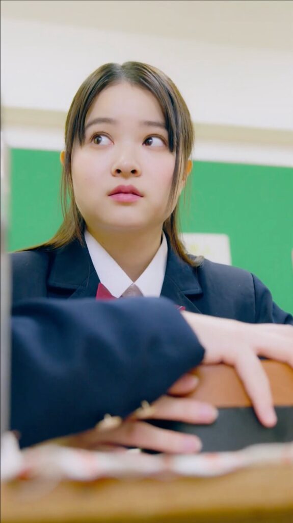 Sc - 縦型ショートドラマなら GOKKO Inc.|ごっこ倶楽部 Young student in a school uniform sits at a desk, looking to the left.