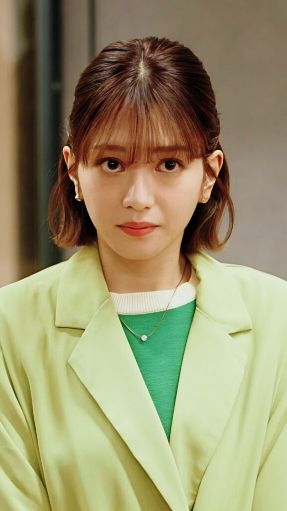 長月翠 様_A - 縦型ショートドラマなら GOKKO Inc.|ごっこ倶楽部 Woman with short brown hair wearing a lime blazer over a green top, neutral expression, small necklace visible in a close-up portrait.