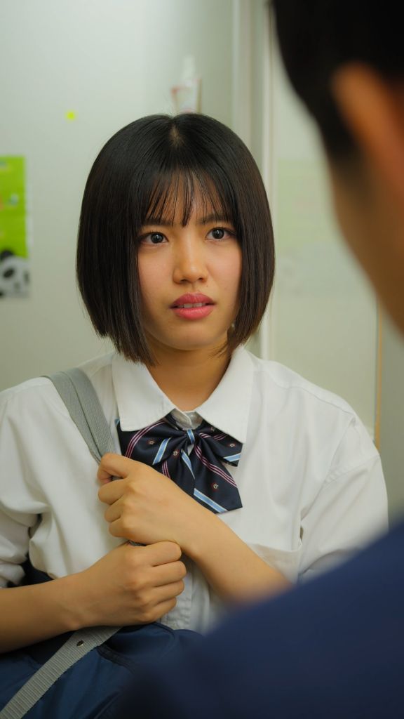 田中舞花さま2 - 縦型ショートドラマなら GOKKO Inc.|ごっこ倶楽部 Young schoolgirl in a white shirt and striped navy tie, holding a bag strap, looking toward someone off-screen in a hallway.