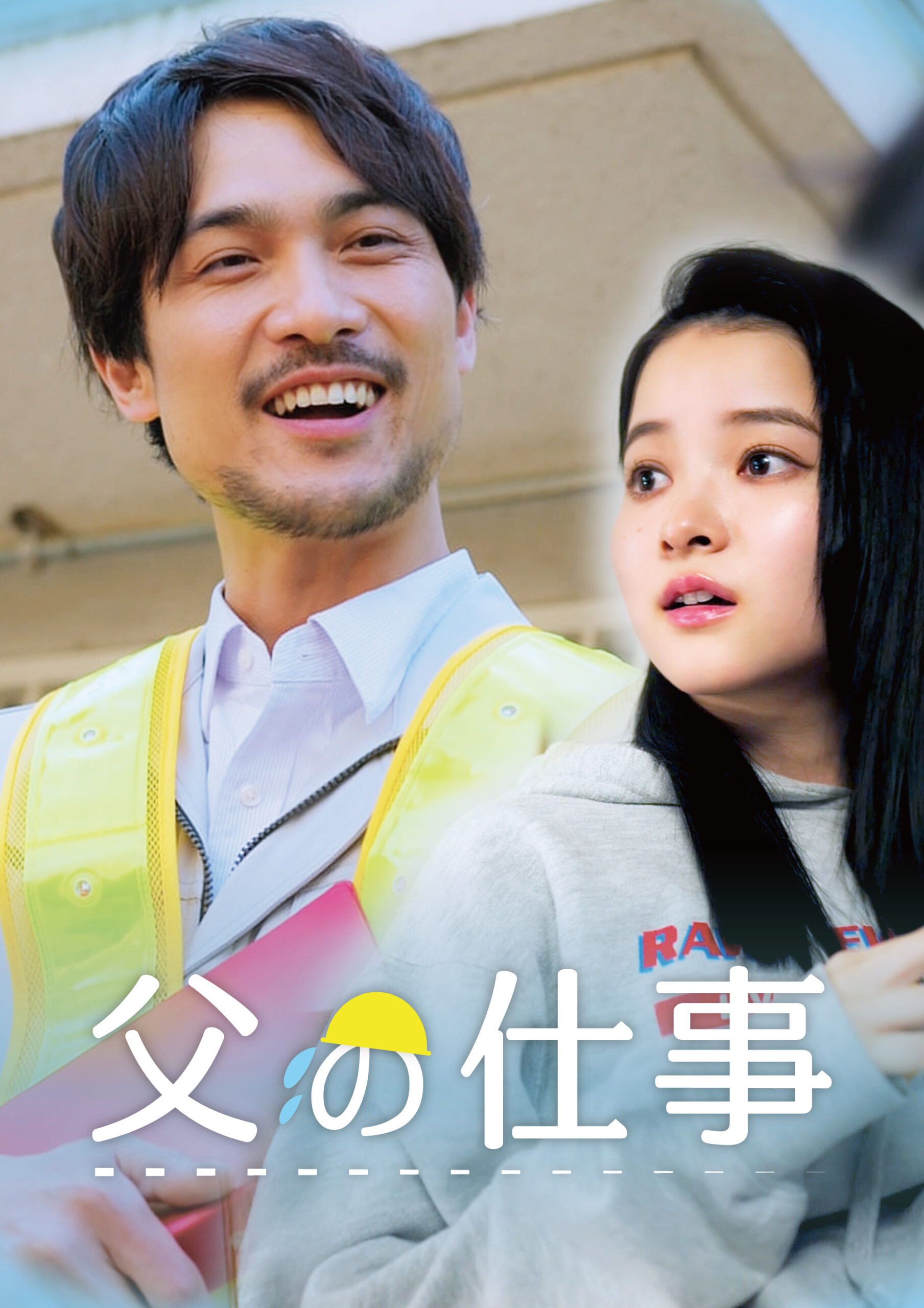 Man in a yellow safety vest smiles broadly, standing next to a woman outdoors, with a building in the background.